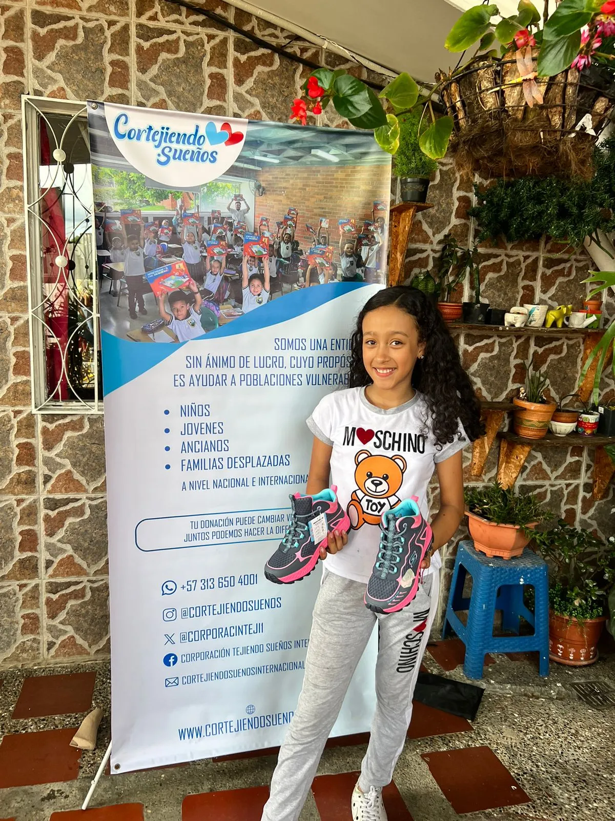 Niña sonríe con zapatos nuevos donados por la fundación